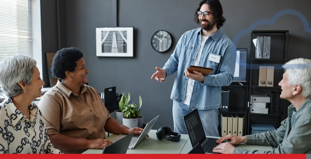 Bearded young man leading computer class for seniors using laptops at table Stock Photo, ft. age discrimination & business - Envato