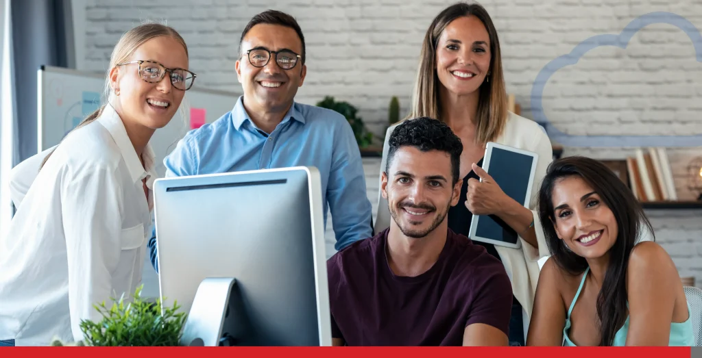 Successful business team standing around computer while looking at camera in the coworking space Stock Photo, ft. adult & back office - Envato